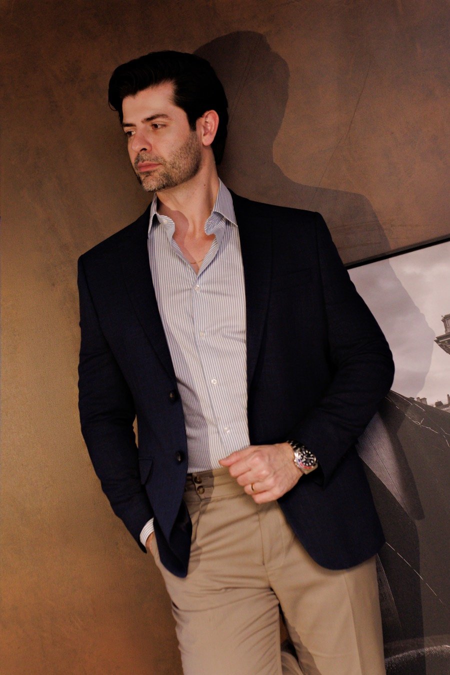 Homem com blazer azul-marinho, camisa social e calça chino em traje esporte fino
